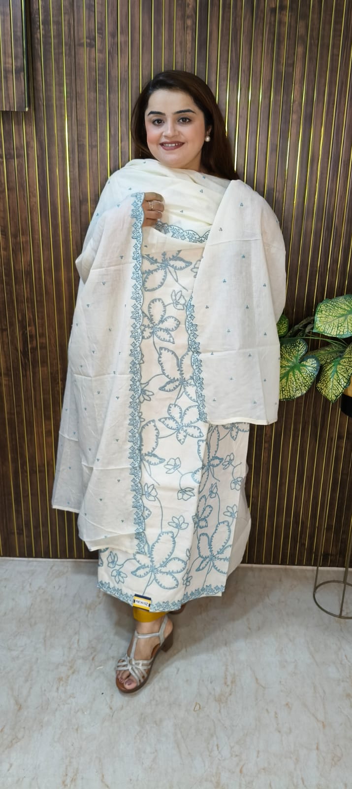 "Elegant White Cotton Suit with Vibrant Threadwork."